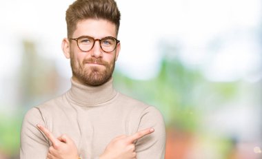 Giyen genç yakışıklı iş adamı için her iki parmak, farklı yönde ile katılmıyorum işaretleme gözlük