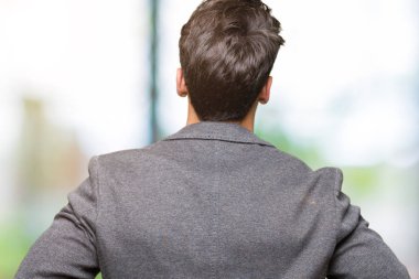 İzole arka plan ayakta geriye doğru uzakta silah ile vücut üzerinde seyir üzerinde gözlük takan genç iş adamı