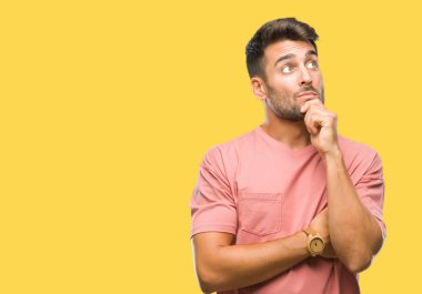 Yakışıklı delikanlı çene düşünme hakkında soru, dalgın ifade üzerine el ile izole arka plan üzerinde. Düşünceli yüzüyle gülümsüyor. Şüphe kavramı.