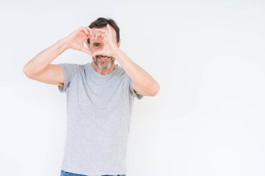 İzole arka plan yaparken kalp şekli ile el ve parmak işareti seyir gülümseyen yakışıklı üst düzey adam