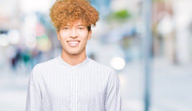 Yüzünde mutlu ve güzel bir gülümseme ile şık gömlek giymiş afro saçlı Genç yakışıklı iş adamı. Şanslı kişi.
