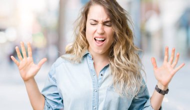 Kızgın ve silah ile başarı için deli kutluyor izole arka plan üzerinde sarışın güzel genç kadın kaldırdı ve heyecanlı çığlık gözler kapalı. Kazanan kavramı