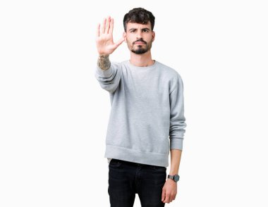 Elin avuç durağı şarkı yapıyor izole arka plan üzerinde sweatshirt giyen genç yakışıklı adam. Negatif ve ciddi bir jest yüz ifadesiyle uyarı.