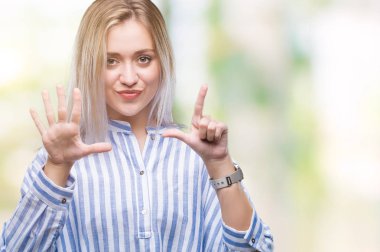 Genç Sarışın kadın gösterilen ve parmakları ile işaret izole arka plan yüzünden kendinden emin ve mutlu gülümseyerek süre yedi numara.