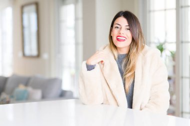 Kış kürk manto evde mutlu ve güzel bir gülümseme ile yüzünde giyen genç güzel kadın. Şanslı kişi.