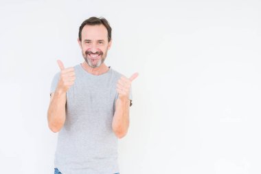 El ile pozitif jest yapıyor izole arka plan başarı işareti üzerinde üst düzey yakışıklı başparmak gülümseyen ve mutlu. Neşeli bir ifadeyle, kazanan jest kameraya bakıyor.