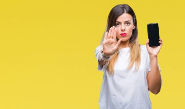 Boş ekran smartphone ile izole arka plan üzerinde gösterilen genç güzel kadın dur işareti ile ciddi ve kendine güvenen ifade, savunma hareketi yaparken el açmak