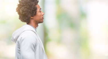 Afro Amerikalı adam giyen kazak izole arka tarafına, seyir üzerinde dinlenmek doğal yüz emin gülümseme ile pozuyla profili.