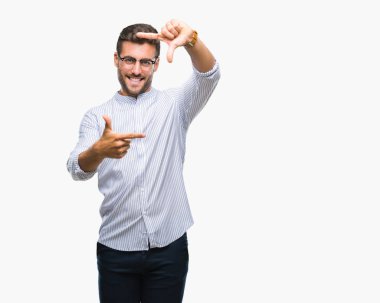 Yakışıklı delikanlı elle yapma çerçeve ve parmakları ile mutlu yüz gülümseyen izole arka plan üzerinde. Yaratıcılık ve Fotoğrafçılık kavramı.