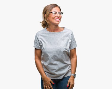 Arka plan uzak tarafına gülümseme ile yüzünde, doğal ifade seyir üzerinde gözlük takan orta yaş İspanyol kadın kıdemli izole. Kendine güvenen gülüyor.