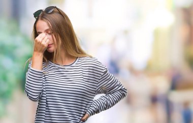 Genç güzel sarışın kadın güneş gözlüğü takıyor izole arka plan üzerinde sürtünme burun ve göz yorgunluğu ve baş ağrısı duygu yorgun. Stres ve hayal kırıklığı kavramı.