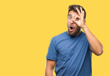 Sürpriz yüz, göz parmaklarının arasından seyir yakışıklı delikanlı ok jest yapıyor izole arka plan üzerinde şok. İmansız ifade.