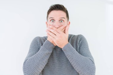 Üzerinde rahat kazak giyen genç yakışıklı adam arka plan ağız hata için elleriyle kapsayan şok izole. Gizli kavramı.