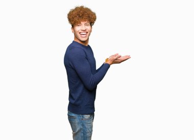 Afro saçlı Genç yakışıklı adam el ve reklam mutlu ve kendinden emin gülümseyen sunulması avuç, yanında işaret