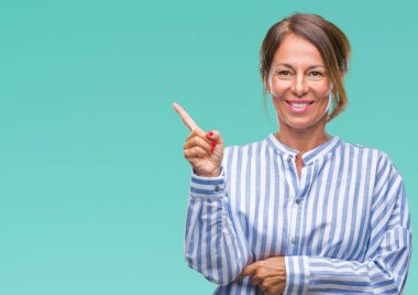 Kameraya bakarak yan el ve parmak ile işaret orta yaş İspanyol kadın kıdemli yüzünde kocaman bir gülümseme ile izole arka plan üzerinde.