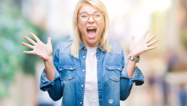 Genç güzel sarışın kadın üzerinde gözlük takan deli kutluyor arka plan izole ve silah ile başarı için yükseltilmiş ve açık gözleri heyecanlı çığlık hayrete düşürdü. Kazanan kavramı