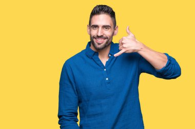 Yakışıklı delikanlı yapıyor gülümseyen izole arka plan üzerinde telefon hareketi ile el ve parmak telefonda konuşuyor gibi. Kavramları iletişim.