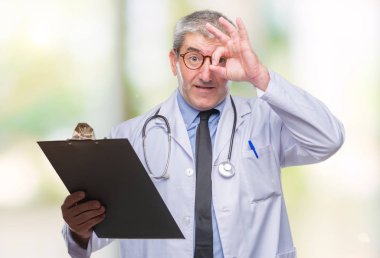 Yakışıklı kıdemli Doktor adam holding Pano ile mutlu yüz el parmaklarının arasından seyir göz üzerinde ok işaretiyle yapıyor gülümseyen izole arka plan üzerinde