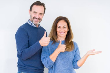Güzel orta yaş kaç aşk içinde arka plan gösteren palm el izole ve mutlu ve neşeli gülümseyen thumbs up, ok hareketi ile yapıyor