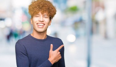 Neşeli bir gülümseme ile el ve parmak kadar yan yüzünde mutlu ve doğal ifade ile işaret yüz afro saçlı Genç yakışıklı adam