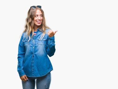 Güzel genç sarışın kadın arıyorum ve başparmak yanında yukarıyı mutlu yüz ile gülümseyen izole arka plan üzerinde güneş gözlüğü takıyor.