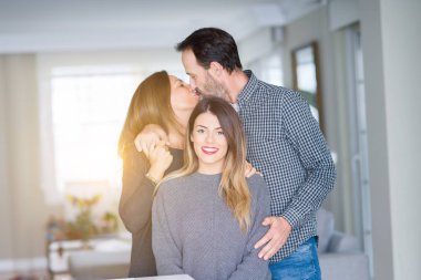Güzel aile birlikte. Anne, baba ve kızı gülümseyen ve evde sevgi ile sarılma.