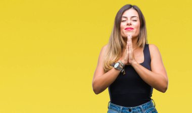 İzole arka plan birlikte emin gülümseyen bağışlanmak ellerle dua genç güzel kadın.