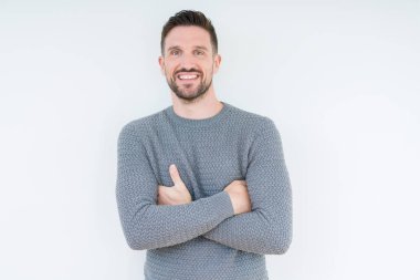 Mutlu yüz ile gülümseyerek kameraya seyir silah geçti arka plan üzerinde rahat kazak giyen genç yakışıklı adam izole. Olumlu bir kişi.