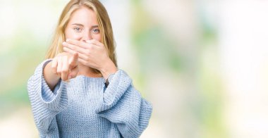 Mavi kazak izole üzerinde giyen güzel genç kadın arka plan sizin parmak el kamerasıyla ağzına, utanç ifadesi işaret eden gülme