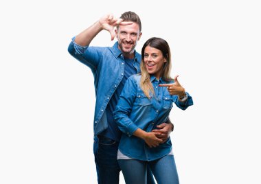 Genç çift elle yapma çerçeve ve parmakları ile mutlu yüz gülümseyen izole arka plan üzerinde aşık. Yaratıcılık ve Fotoğrafçılık kavramı.