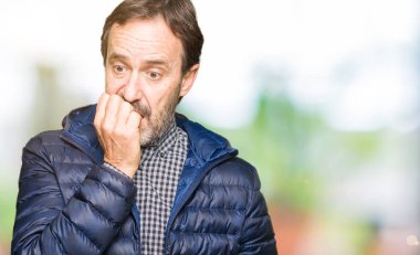 Orta yaş yakışıklı adam stresli ve gergin ile kış ceket giyen tırnak ısırma dudaklarından eller. Anksiyete sorunu.