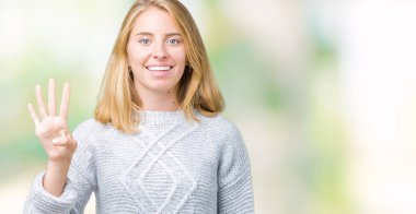 Güzel genç kadın giyiyor kış kazak gösterilen ve parmakları ile işaret izole arka plan üzerinde dört kendinden emin ve mutlu gülümseyerek iken numara.