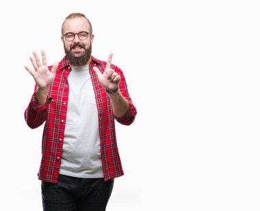 Gösterilen arka plan üzerinde gözlük takan Genç beyaz hipster adam izole ve parmakları ile işaret kendinden emin ve mutlu gülümseyerek süre yedi numara.
