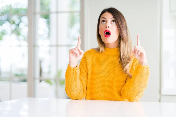 Mooie Jongedame Dragen Winter Trui Thuis Verbaasd Verrast Opzoeken Wijzen — Stockfoto