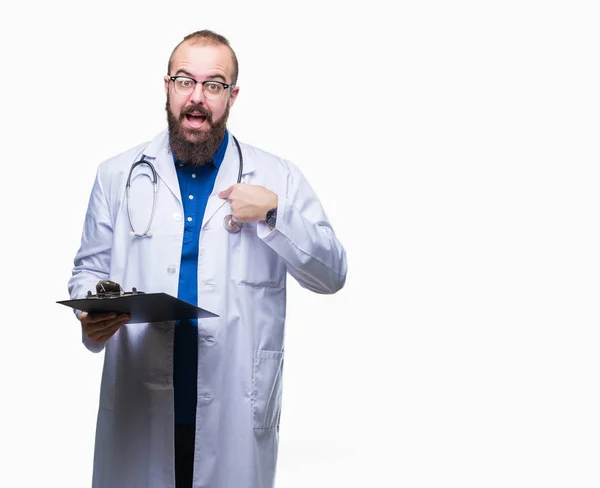 若い医者の男の指を指す自身驚き顔で孤立した背景にクリップボードを保持 — ストック写真