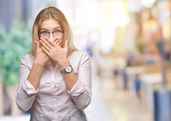 若い白人のビジネス女性が眼鏡をかけてミスのため手で口を覆っているショックを受けて孤立の背景の上 秘密の概念 — ストック写真