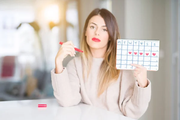 Junge Schöne Frau Mit Einem Menstruationskalender Hause Und Selbstbewusstem Gesichtsausdruck — Stockfoto
