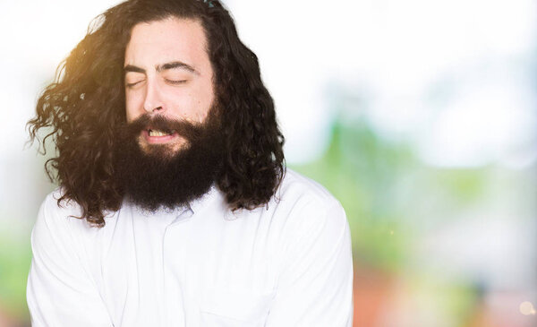 Man wearing Jesus Christ costume with hand on stomach because nausea, painful disease feeling unwell. Ache concept.