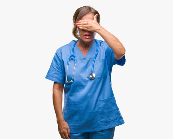 中年老年护士医生妇女在孤立的背景下微笑和笑着用手捂住眼睛惊喜 盲目的概念 — 图库照片