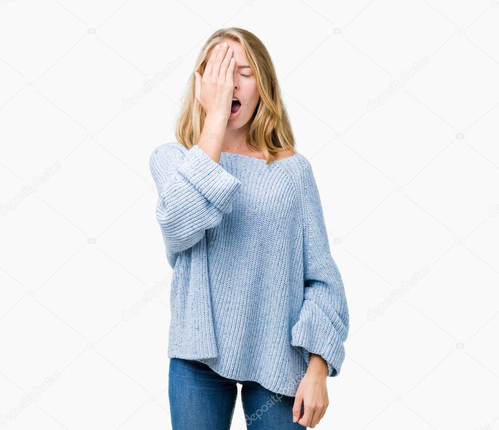 Beautiful young woman wearing blue sweater over isolated background Yawning tired covering half face, eye and mouth with hand. Face hurts in pain.