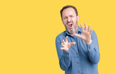 Şokta bağırarak yakışıklı orta yaş zarif üst düzey adam izole arka plan korkuyor ve korku ifade dur hareketi el ile ile çok korkmuş. Panik kavramı.