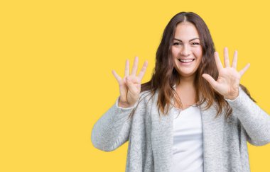 Parmakları ile dokuz kendinden emin ve mutlu gülümseyerek süre güzel artı boyutu genç kadın giyiyor kış ceket ve yukarıyı gösteren izole arka plan üzerinde numara.