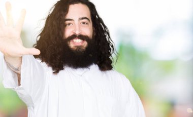 Gösterilen ve parmakları ile işaret İsa Mesih giyinen adam kendinden emin ve mutlu gülümseyerek süre 5 numara.