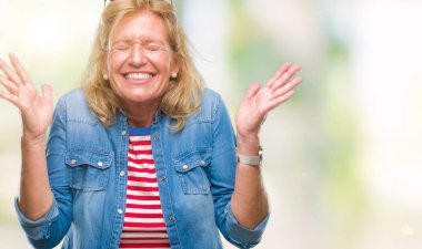 Orta yaş sarışın kadın deli ve silah ile başarı için deli kutluyor izole arka plan üzerinde kaldırdı ve heyecanlı çığlık gözler kapalı. Kazanan kavramı