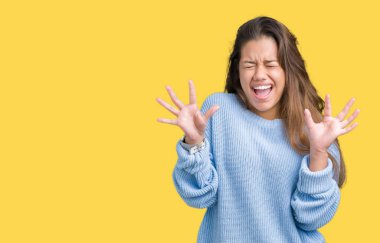 Üzerinde mavi kış kazak giyen genç güzel esmer kadın arka plan deli kutluyor izole ve crazy arms ile başarı için kaldırdı ve heyecanlı çığlık gözler kapalı. Kazanan kavramı