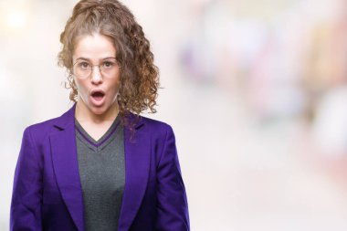 Okul üniforması giyen genç esmer öğrenci kız ve gözlük korkuyor ve şok sürpriz ifade ile izole arka plan üzerinde korku ve yüz heyecanlı.