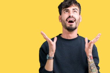 Genç yakışıklı adam izole arka plan çılgın ve kızgın bağırarak ve agresif ifade ve silah kaldırdı bağırıyor. Hayal kırıklığı kavramı.