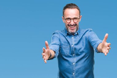 Sarılmak için kollarını açarak gülümseyerek kameraya bakarak izole arka plan üzerinde gözlük takan orta yaş ağarmış komuta sizde. Neşeli ifade kucaklayan mutluluk.