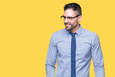 İzole arka plan uzak tarafına gülümseme ile yüzünde, doğal ifade bakmaktan gözlüklü genç iş adamı. Kendine güvenen gülüyor.