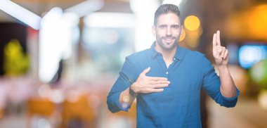 İzole genç yakışıklı adam arka plan Swearing göğüs ve parmaklar, el ile bir sadakat sözü yemin yapma
